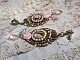 BO Sissi Imp&eacute;ratrice dans les tons rose et bronze, pendentifs, strass, cha&icirc;ne perl&eacute;e, gouttes et clous d'oreilles en ml&eacute;tal en verre, breloques couronnes