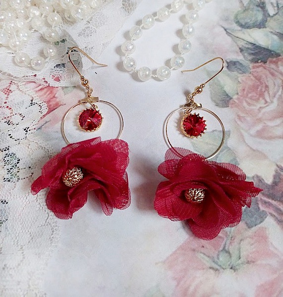 Boucles d'oreilles créoles dorées avec fleurs rouges et cristaux.