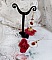 Boucles d'oreilles créoles dorées avec fleurs rouges et cristaux.