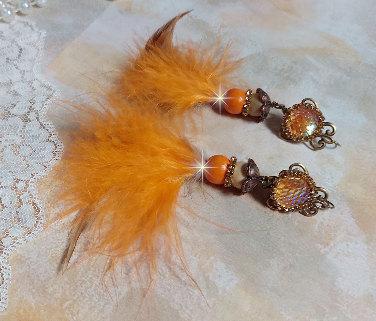 BO Vol au Vent cr&eacute;&eacute;es avec plumes de pintade, Coq trois tons, plumes Orange, perles bois naturel et Orange, perles r&eacute;sine et cha&icirc;ne strass. 