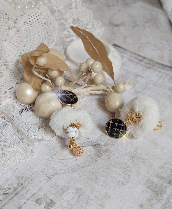 BO Cassandre avec des pierres de gemme : le Howlite Blanc &agrave; laquelle s&rsquo;ajoute des pompons, des intercalaires rondelles, des coupelles feuilles et breloques. Mont&eacute;s sur des puces Noires et Dor&eacute;es 