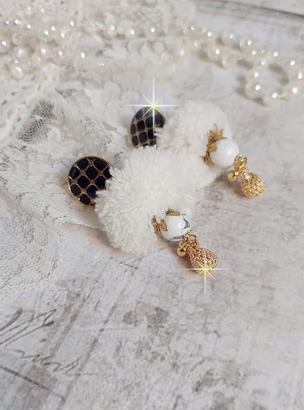 BO Cassandre avec des pierres de gemme : le Howlite Blanc &agrave; laquelle s&rsquo;ajoute des pompons, des intercalaires rondelles, des coupelles feuilles et breloques. Mont&eacute;s sur des puces Noires et Dor&eacute;es 
