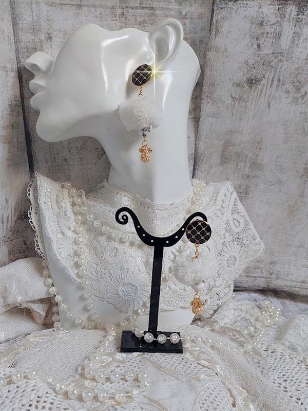 BO Cassandre avec des pierres de gemme : le Howlite Blanc &agrave; laquelle s&rsquo;ajoute des pompons, des intercalaires rondelles, des coupelles feuilles et breloques. Mont&eacute;s sur des puces Noires et Dor&eacute;es 