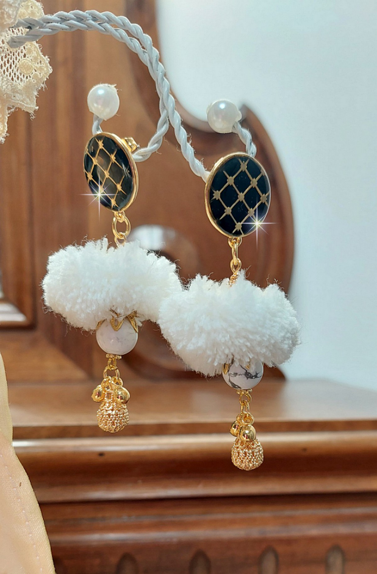BO Cassandre avec des pierres de gemme : le Howlite Blanc &agrave; laquelle s&rsquo;ajoute des pompons, des intercalaires rondelles, des coupelles feuilles et breloques. Mont&eacute;s sur des puces Noires et Dor&eacute;es 