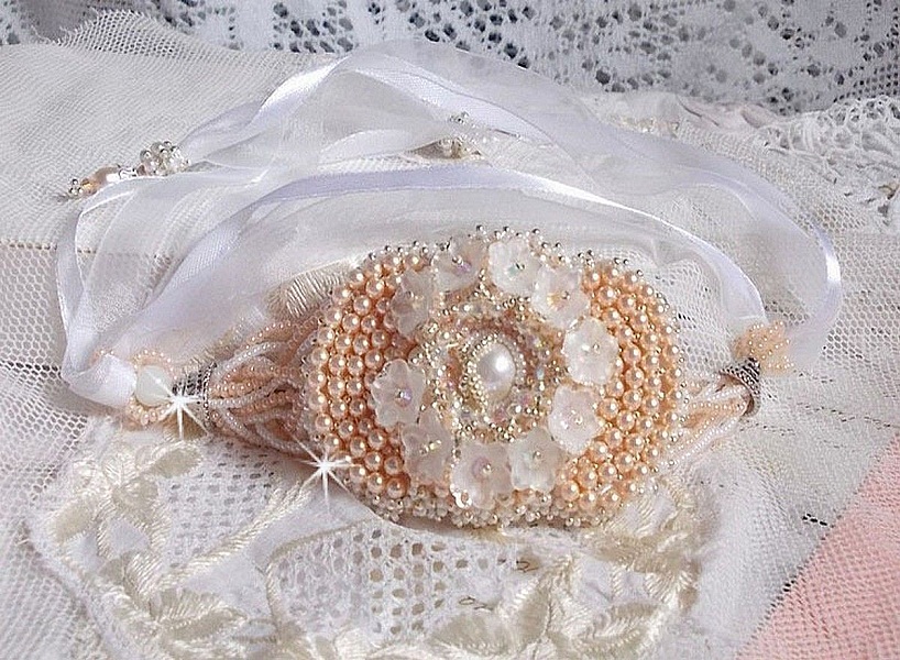 Bracelet Bouquet d'un Jour brod&eacute; avec un cabochon rond couleur Ivoire, fleurs en Lucite entrelac&eacute;es avec des rocailles, toupies en Cristal et Light Peach de qualit&eacute; AB2X &agrave; laquelle s'ajoute des rubans