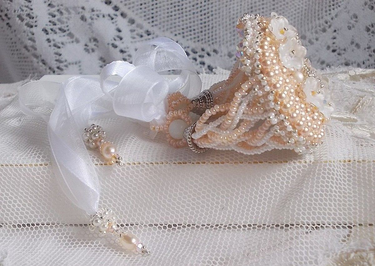 Bracelet Bouquet d'un Jour brod&eacute; avec un cabochon rond couleur Ivoire, fleurs en Lucite entrelac&eacute;es avec des rocailles, toupies en Cristal et Light Peach de qualit&eacute; AB2X &agrave; laquelle s'ajoute des rubans