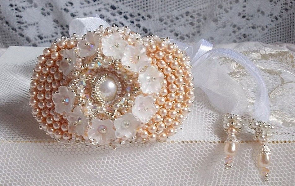 Bracelet Bouquet d'un Jour brod&eacute; avec un cabochon rond couleur Ivoire, fleurs en Lucite entrelac&eacute;es avec des rocailles, toupies en Cristal et Light Peach de qualit&eacute; AB2X &agrave; laquelle s'ajoute des rubans
