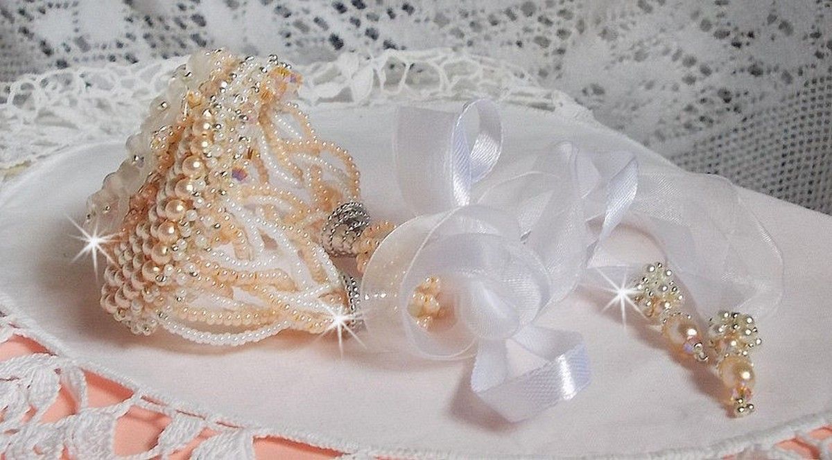 Bracelet Bouquet d'un Jour brod&eacute; avec un cabochon rond couleur Ivoire, fleurs en Lucite entrelac&eacute;es avec des rocailles, toupies en Cristal et Light Peach de qualit&eacute; AB2X &agrave; laquelle s'ajoute des rubans