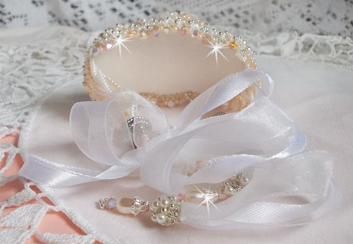 Bracelet Bouquet d'un Jour brod&eacute; avec un cabochon rond couleur Ivoire, fleurs en Lucite entrelac&eacute;es avec des rocailles, toupies en Cristal et Light Peach de qualit&eacute; AB2X &agrave; laquelle s'ajoute des rubans