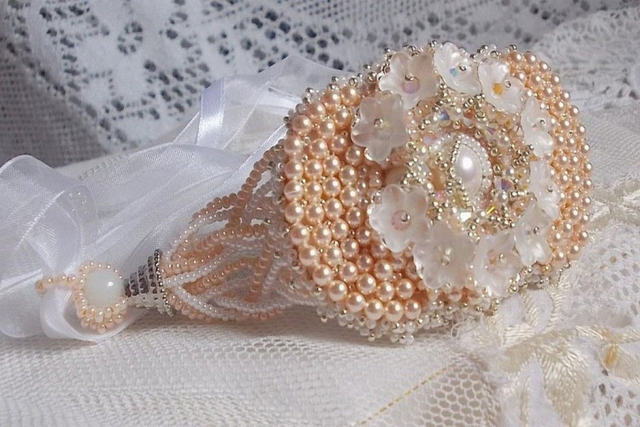 Bracelet Bouquet d'un Jour brod&eacute; avec un cabochon rond couleur Ivoire, fleurs en Lucite entrelac&eacute;es avec des rocailles, toupies en Cristal et Light Peach de qualit&eacute; AB2X &agrave; laquelle s'ajoute des rubans