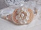 Bracelet Bouquet d'un Jour brod&eacute; avec un cabochon rond couleur Ivoire, fleurs en Lucite entrelac&eacute;es avec des rocailles, toupies en Cristal et Light Peach de qualit&eacute; AB2X &agrave; laquelle s'ajoute des rubans