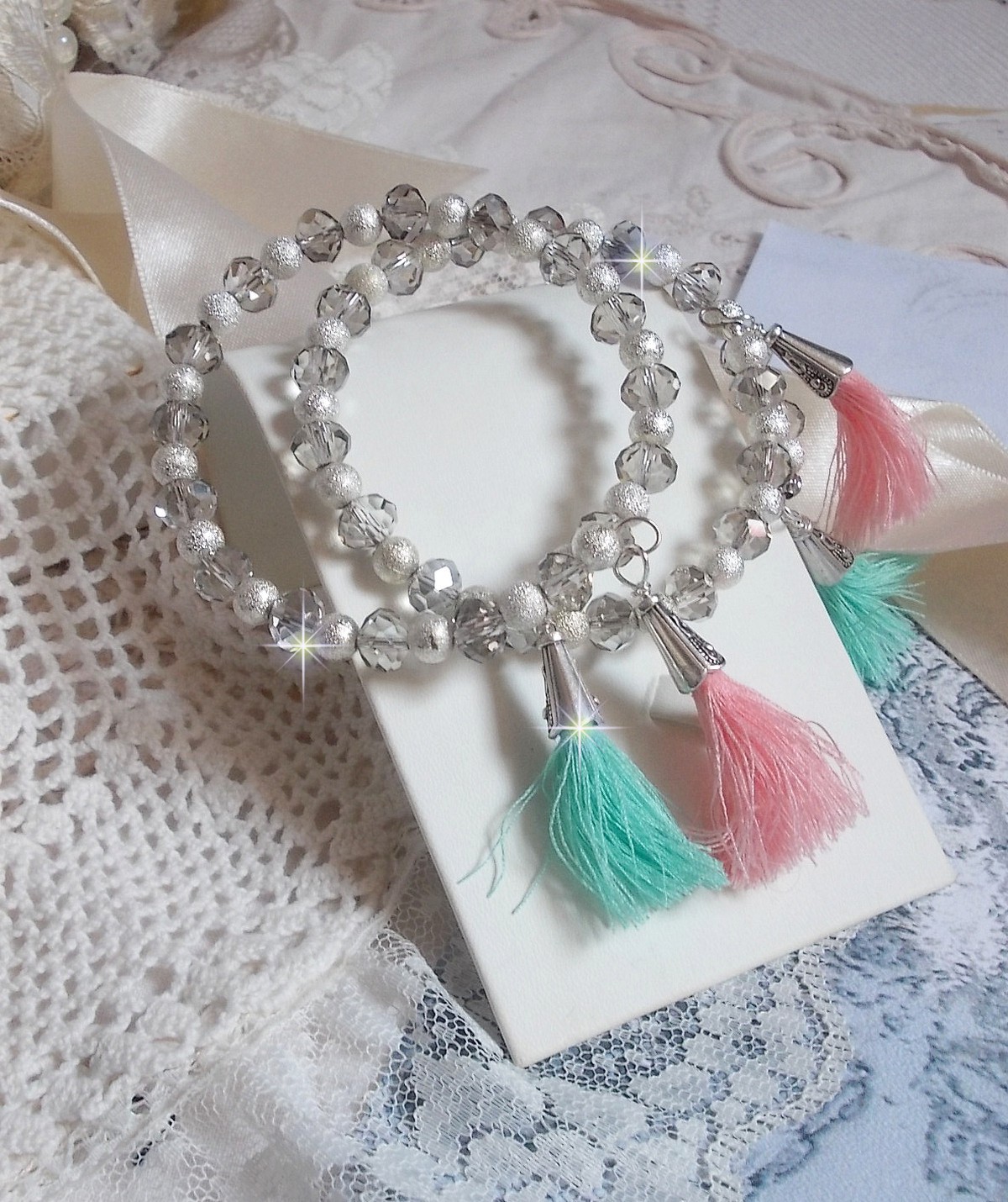 Bracelets Cristalline Eclat avec doubles bracelets aux perles Stardust Argent&eacute;es effet paillet&eacute;, perles rondes facett&eacute;es en verre et pompons couleur Rose et Menthe pour un style contemporain