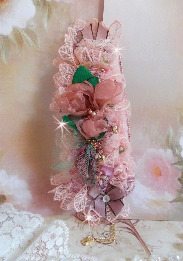 Bracelet Douceur Poudr&eacute;e manchette brod&eacute; avec une dentelle motif floral, ruban organza, tulles, n&oelig;uds, &eacute;tamines, sequins paillettes. La couleur dominante est le Rose &agrave; laquelle s&rsquo;ajoute des cristaux 
