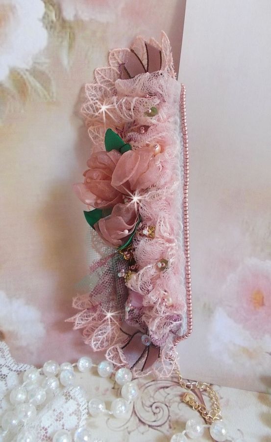 Bracelet Douceur Poudr&eacute;e manchette brod&eacute; avec une dentelle motif floral, ruban organza, tulles, n&oelig;uds, &eacute;tamines, sequins paillettes. La couleur dominante est le Rose &agrave; laquelle s&rsquo;ajoute des cristaux 