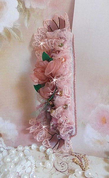 Bracelet Douceur Poudr&eacute;e manchette brod&eacute; avec une dentelle motif floral, ruban organza, tulles, n&oelig;uds, &eacute;tamines, sequins paillettes. La couleur dominante est le Rose &agrave; laquelle s&rsquo;ajoute des cristaux 