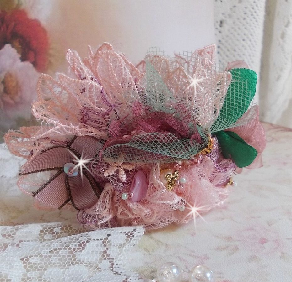 Bracelet Douceur Poudr&eacute;e manchette brod&eacute; avec une dentelle motif floral, ruban organza, tulles, n&oelig;uds, &eacute;tamines, sequins paillettes. La couleur dominante est le Rose &agrave; laquelle s&rsquo;ajoute des cristaux 