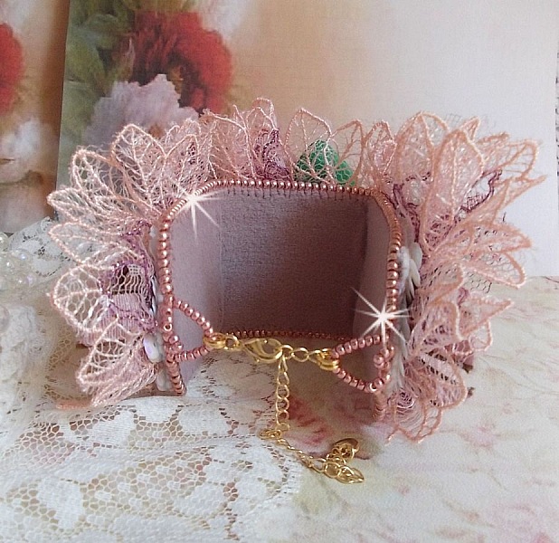 Bracelet Douceur Poudr&eacute;e manchette brod&eacute; avec une dentelle motif floral, ruban organza, tulles, n&oelig;uds, &eacute;tamines, sequins paillettes. La couleur dominante est le Rose &agrave; laquelle s&rsquo;ajoute des cristaux 