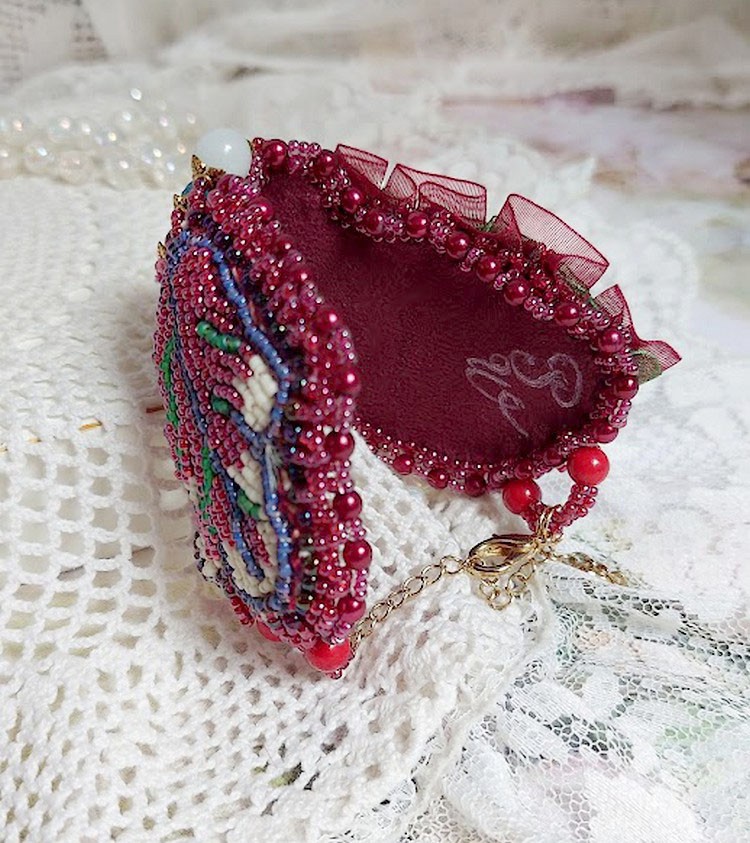 Bracelet manchette brodé de perles rouges et dentelle élégante.