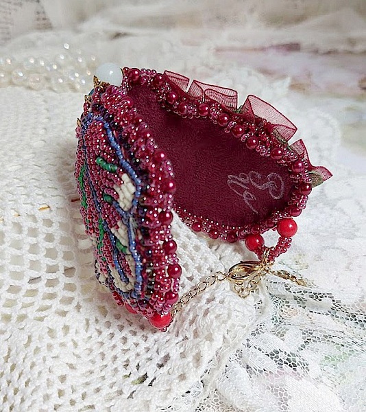 Bracelet manchette brodé de perles rouges et dentelle élégante.