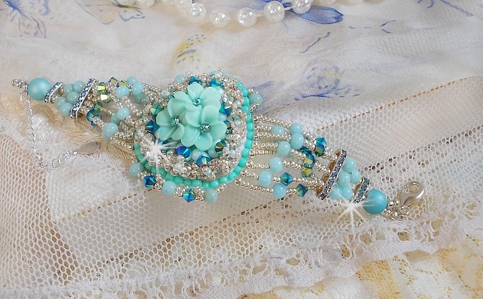 Bracelet Blue Flowers Haute-Couture brod&eacute; avec des Cristaux de Swarovski, un cabochon en r&eacute;sine, des perles rondes en satin, des rocailles avec une cha&icirc;nette et un fermoir en Argent 925/1000