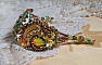 Bracelet artisanal brodé en soie et perles aux tons chauds.