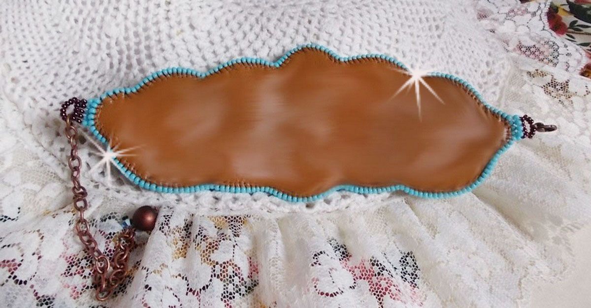 Dos en cuir marron d'une manchette artisanale perlée turquoise.