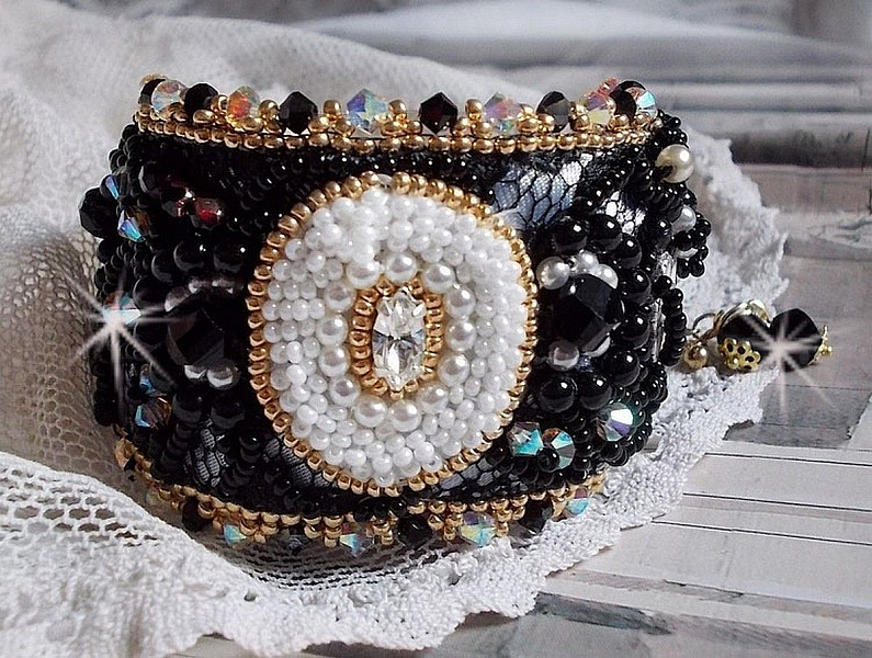 Bracelet Noir Sacr&eacute; Haute Couture brod&eacute; avec des cristaux : navette, h&eacute;lix Bead,, toupies, breloque fleur strass&eacute;e,  perles rondes nacr&eacute;es Verre et rocailles. Les couleurs sont le Noir, Blanc et Dor&eacute;