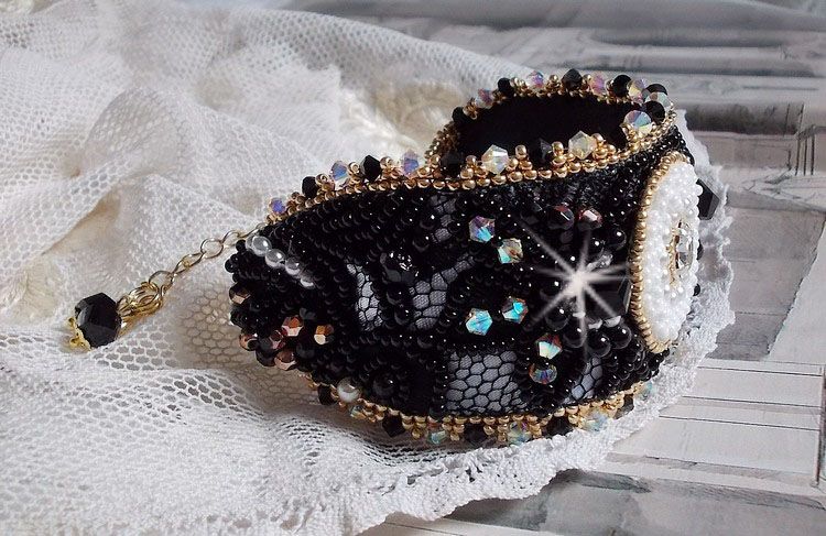 Bracelet Noir Sacr&eacute; Haute Couture brod&eacute; avec des cristaux : navette, h&eacute;lix Bead,, toupies, breloque fleur strass&eacute;e,  perles rondes nacr&eacute;es Verre et rocailles. Les couleurs sont le Noir, Blanc et Dor&eacute;