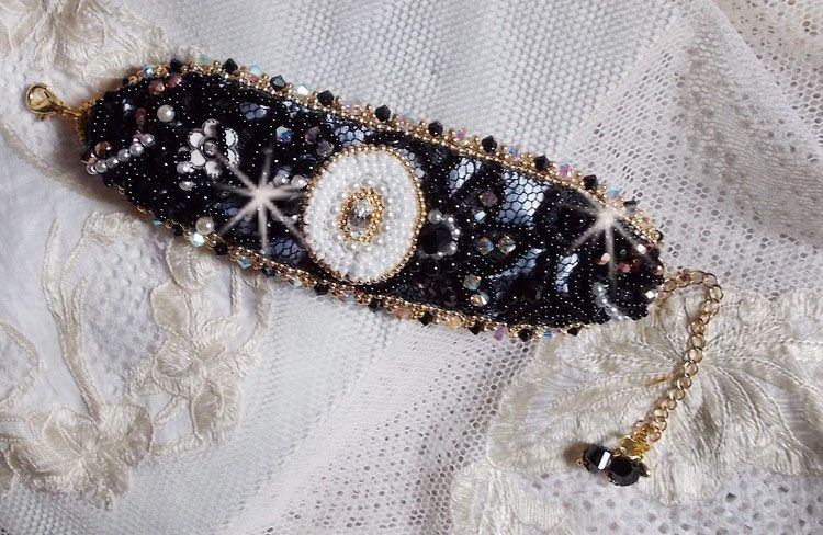 Bracelet Noir Sacr&eacute; Haute Couture brod&eacute; avec des cristaux : navette, h&eacute;lix Bead,, toupies, breloque fleur strass&eacute;e,  perles rondes nacr&eacute;es Verre et rocailles. Les couleurs sont le Noir, Blanc et Dor&eacute;
