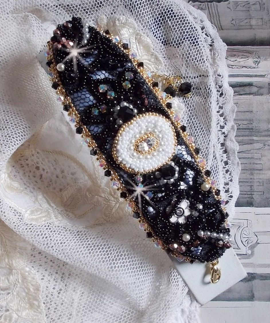 Bracelet Noir Sacr&eacute; Haute Couture brod&eacute; avec des cristaux : navette, h&eacute;lix Bead,, toupies, breloque fleur strass&eacute;e,  perles rondes nacr&eacute;es Verre et rocailles. Les couleurs sont le Noir, Blanc et Dor&eacute;