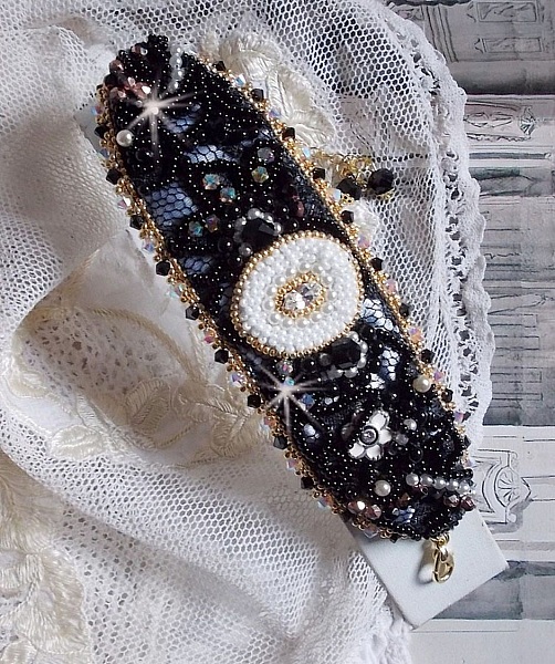 Bracelet Noir Sacr&eacute; Haute Couture brod&eacute; avec des cristaux : navette, h&eacute;lix Bead,, toupies, breloque fleur strass&eacute;e,  perles rondes nacr&eacute;es Verre et rocailles. Les couleurs sont le Noir, Blanc et Dor&eacute;