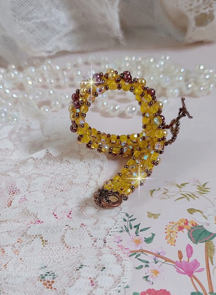 Bracelet Soleil mont&eacute; avec des facettes en verre de boh&egrave;me aux couleurs Topaze AB &agrave; laquelle s&rsquo;ajoute des perles rondes nacr&eacute;es Gold et Maron o&ugrave; elles s&rsquo;entrelacent avec les rocailles Dor&eacute;es satin&eacute;es