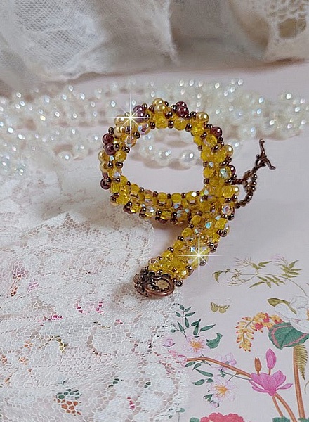 Bracelet Soleil mont&eacute; avec des facettes en verre de boh&egrave;me aux couleurs Topaze AB &agrave; laquelle s&rsquo;ajoute des perles rondes nacr&eacute;es Gold et Maron o&ugrave; elles s&rsquo;entrelacent avec les rocailles Dor&eacute;es satin&eacute;es