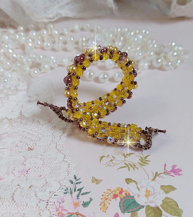 Bracelet Soleil mont&eacute; avec des facettes en verre de boh&egrave;me aux couleurs Topaze AB &agrave; laquelle s&rsquo;ajoute des perles rondes nacr&eacute;es Gold et Maron o&ugrave; elles s&rsquo;entrelacent avec les rocailles Dor&eacute;es satin&eacute;es