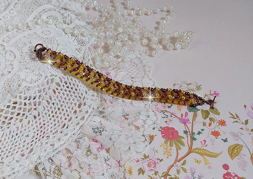 Bracelet Soleil mont&eacute; avec des facettes en verre de boh&egrave;me aux couleurs Topaze AB &agrave; laquelle s&rsquo;ajoute des perles rondes nacr&eacute;es Gold et Maron o&ugrave; elles s&rsquo;entrelacent avec les rocailles Dor&eacute;es satin&eacute;es