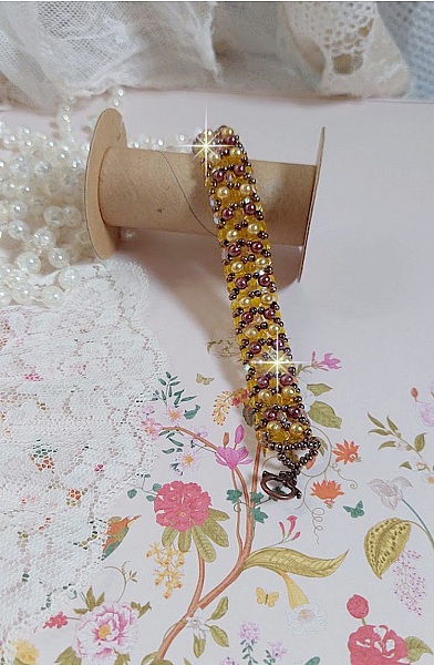 Bracelet Soleil mont&eacute; avec des facettes en verre de boh&egrave;me aux couleurs Topaze AB &agrave; laquelle s&rsquo;ajoute des perles rondes nacr&eacute;es Gold et Maron o&ugrave; elles s&rsquo;entrelacent avec les rocailles Dor&eacute;es satin&eacute;es