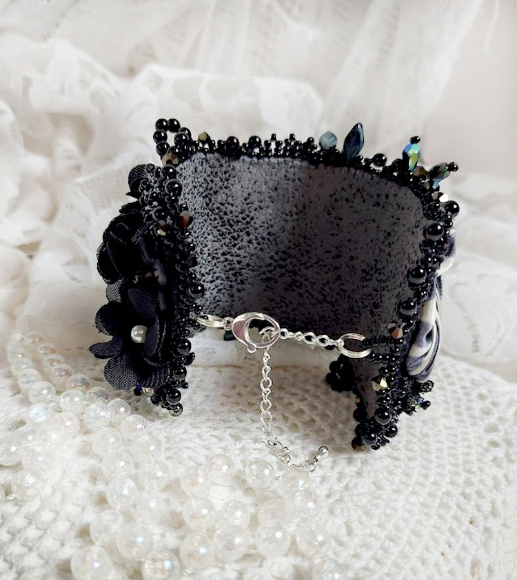 Bracelet manchette noir brodé avec perles et fleurs élégantes.