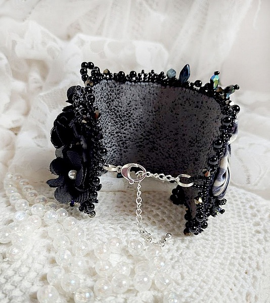 Bracelet manchette noir brodé avec perles et fleurs élégantes.