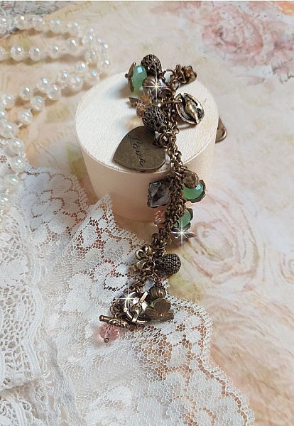 Bracelet Temps d&rsquo;une Folie avec breloques : c&oelig;ur, perles, gouttes filigran&eacute;es, fleurs &eacute;maill&eacute;es, perles rondes, cabochons carr&eacute;s et perles rondes en Verre. Mont&eacute;s sur cha&icirc;nes et fermoir en T Bronze