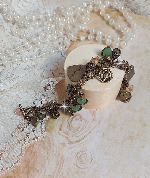 Bracelet Temps d&rsquo;une Folie avec breloques : c&oelig;ur, perles, gouttes filigran&eacute;es, fleurs &eacute;maill&eacute;es, perles rondes, cabochons carr&eacute;s et perles rondes en Verre. Mont&eacute;s sur cha&icirc;nes et fermoir en T Bronze