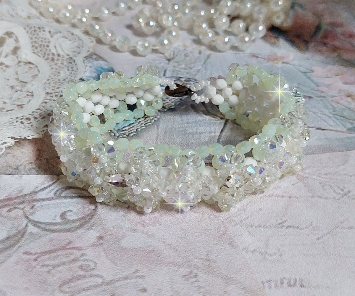 Bracelet V&eacute;nus mont&eacute; avec une cascade de cristaux : toupies et navettes en Cristal AB ainsi que les facettes de couleur Blanche et Beige Opaque de qualit&eacute; AB, puis perl&eacute; de rocailles nacr&eacute;es 
