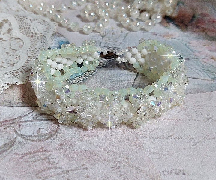 Bracelet V&eacute;nus mont&eacute; avec une cascade de cristaux : toupies et navettes en Cristal AB ainsi que les facettes de couleur Blanche et Beige Opaque de qualit&eacute; AB, puis perl&eacute; de rocailles nacr&eacute;es 