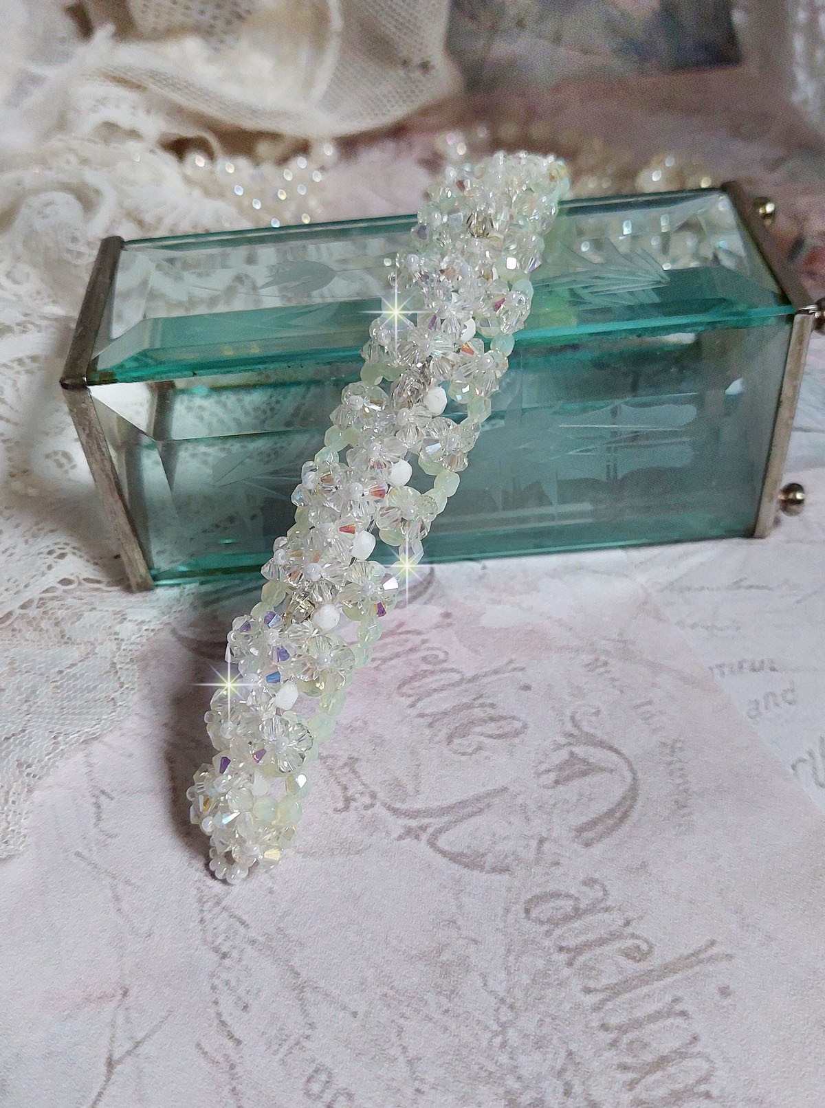 Bracelet V&eacute;nus mont&eacute; avec une cascade de cristaux : toupies et navettes en Cristal AB ainsi que les facettes de couleur Blanche et Beige Opaque de qualit&eacute; AB, puis perl&eacute; de rocailles nacr&eacute;es 