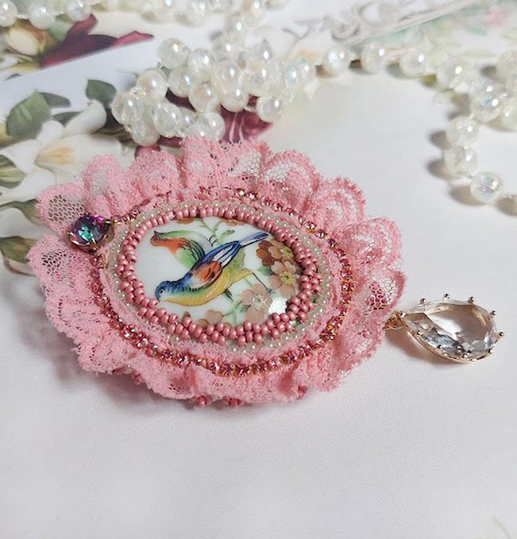 Broche Amour d&rsquo;oiseaux brod&eacute;e avec cabochon porcelaine de limoge, perle cristal, dentelle et pendentif cristal de verre