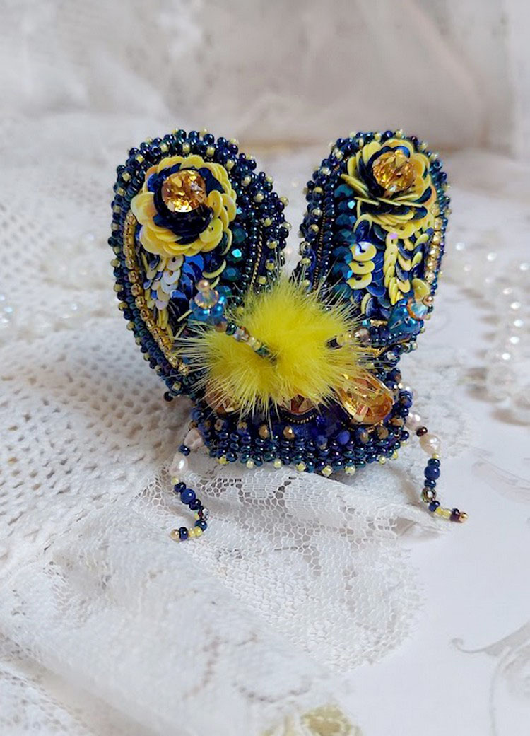Broche artisanale bleue et jaune brodée de perles et cristaux.