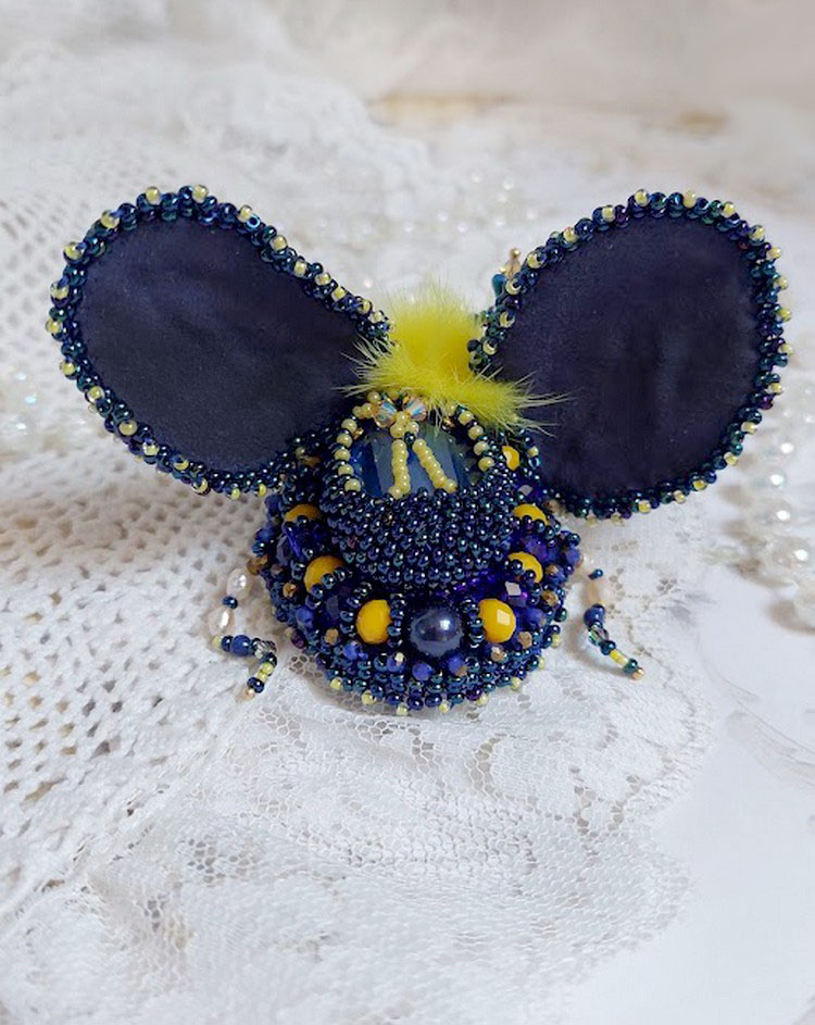 Broche artisanale bleue et jaune brodée de perles et cristaux.