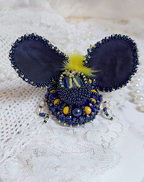 Broche artisanale bleue et jaune brodée de perles et cristaux.