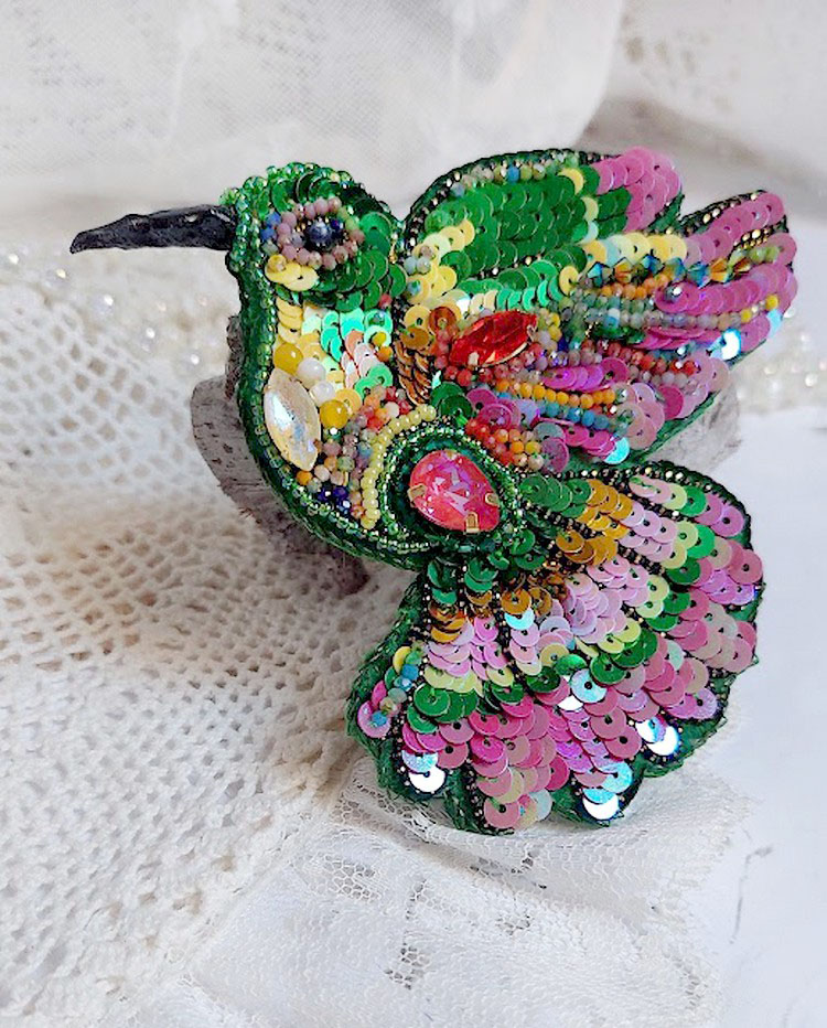 Broche colibri brodée de sequins et cristaux colorés.