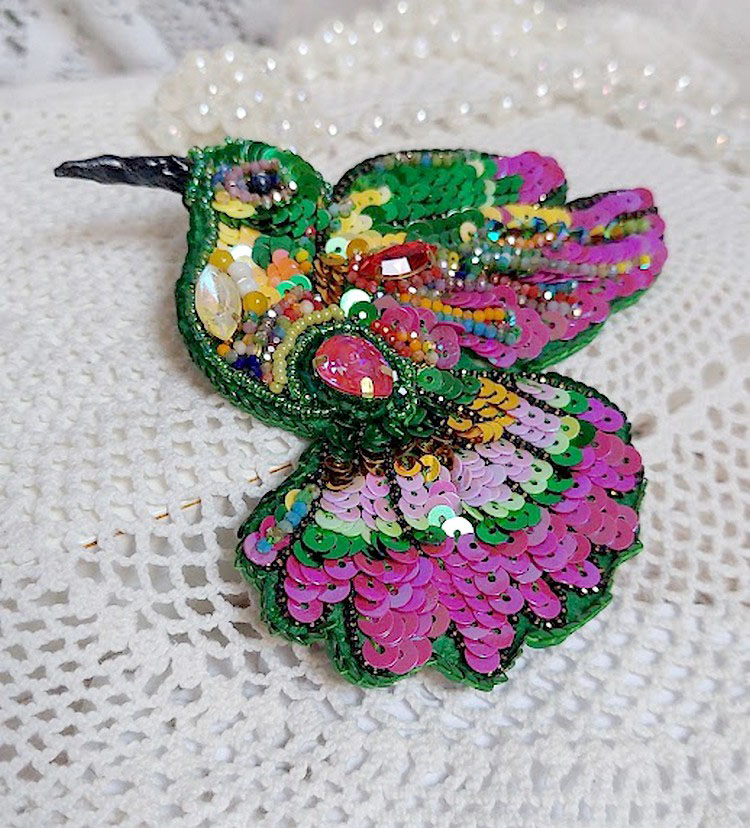 Broche colibri brodée de sequins et perles colorées.