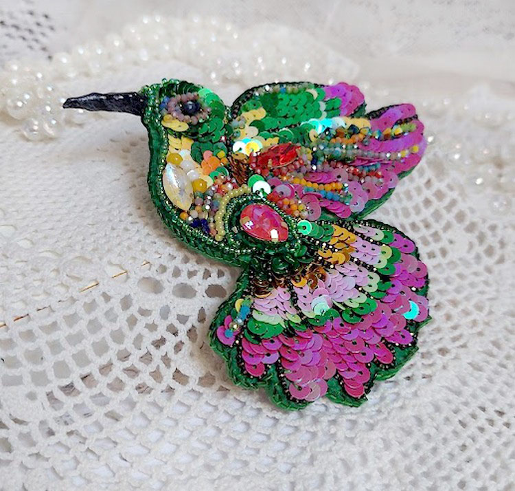 Broche colibri brodée de sequins et perles colorées.
